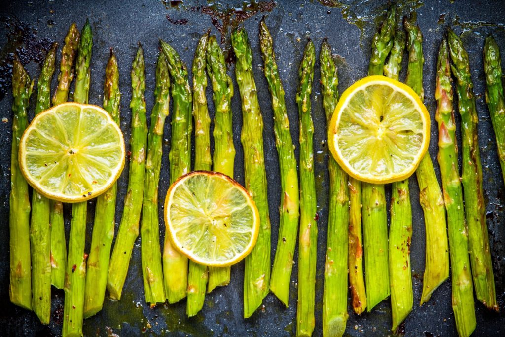 foods that reduce anxiety - baked asparagus with lemon on a dark background