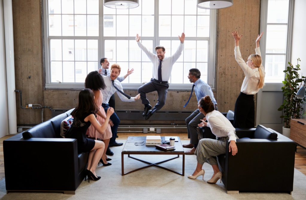 group of motivated coworkers celebrating at work