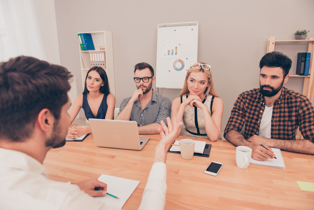 group of millennials interviewing man - tips for a successful job interview
