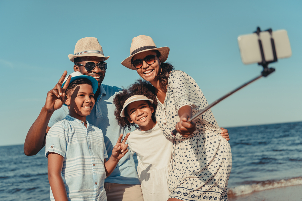 family taking a selfie on the beach - avoiding social media comparison traps