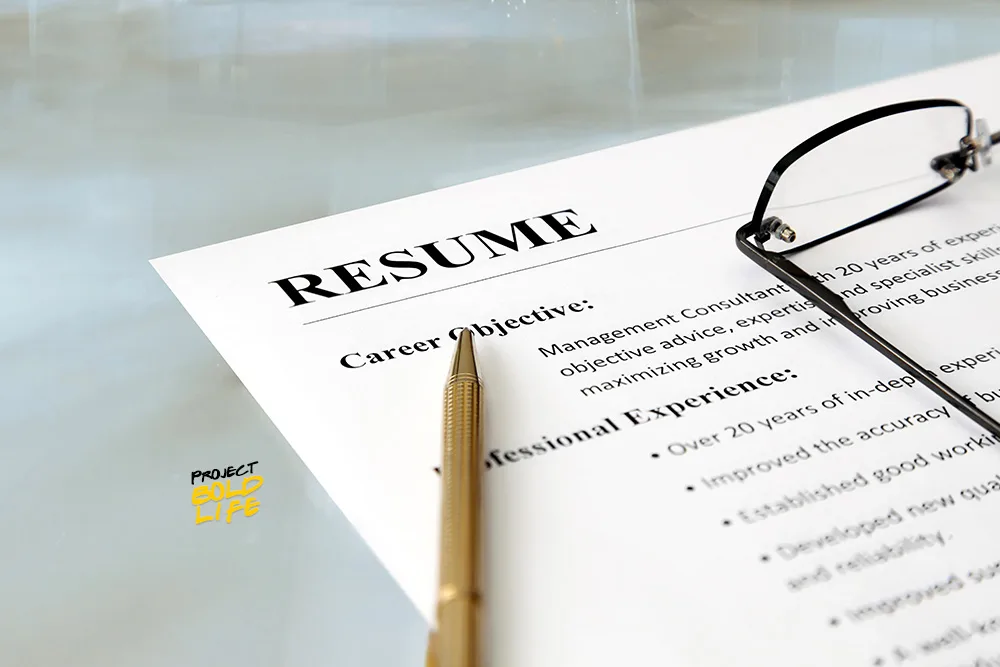 example for how to write a resume that gets noticed on desk with pen and glasses