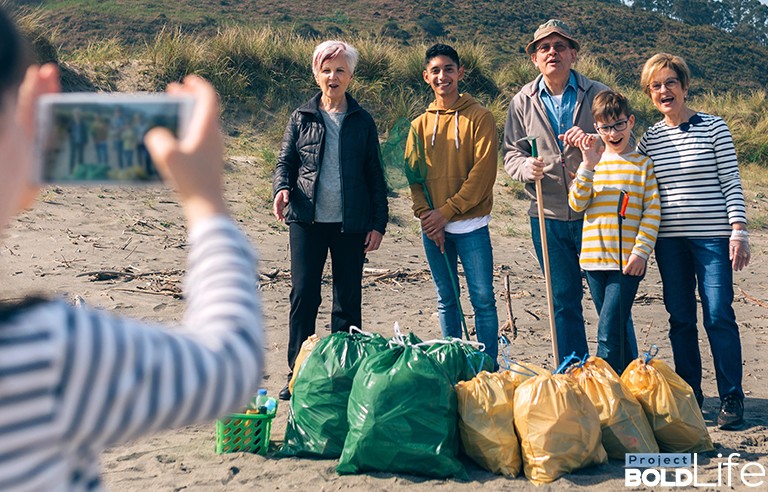 A family happily collecting trash on the beach