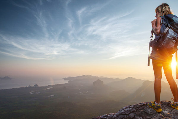 woman standing on a cliff searching for adventure looking for cure for boredom