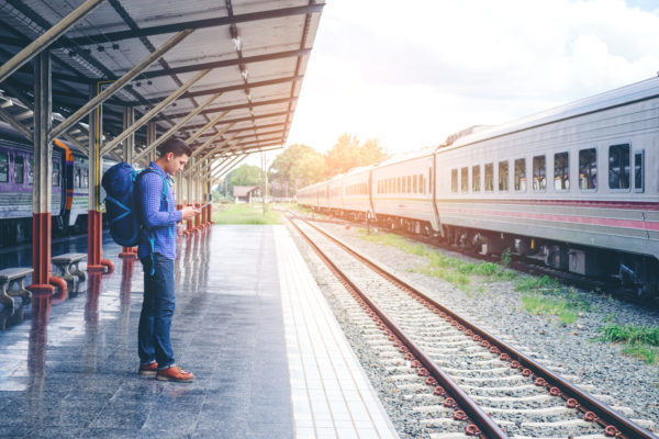 solo traveler man waits train on railway platform
