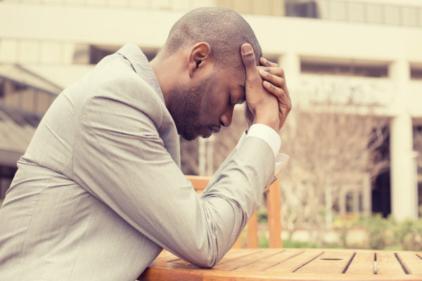 man outside at a table suffering from brain fog