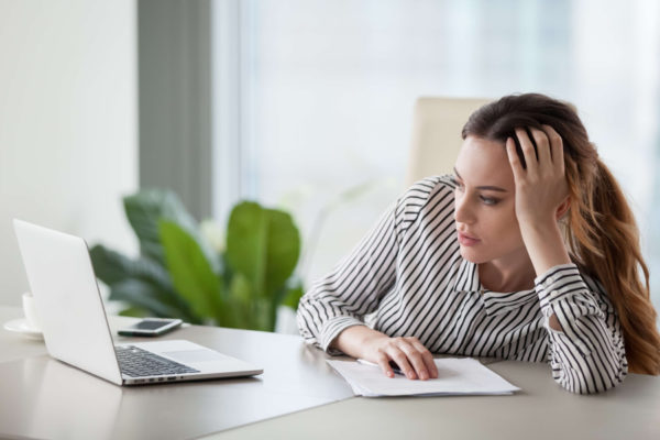woman staring blankly at her computer feeling unmotivated