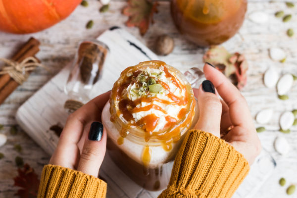 hands holding pumpkin spice latte