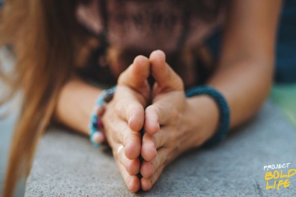 girl with hands together practicing teachings from spiritual gurus