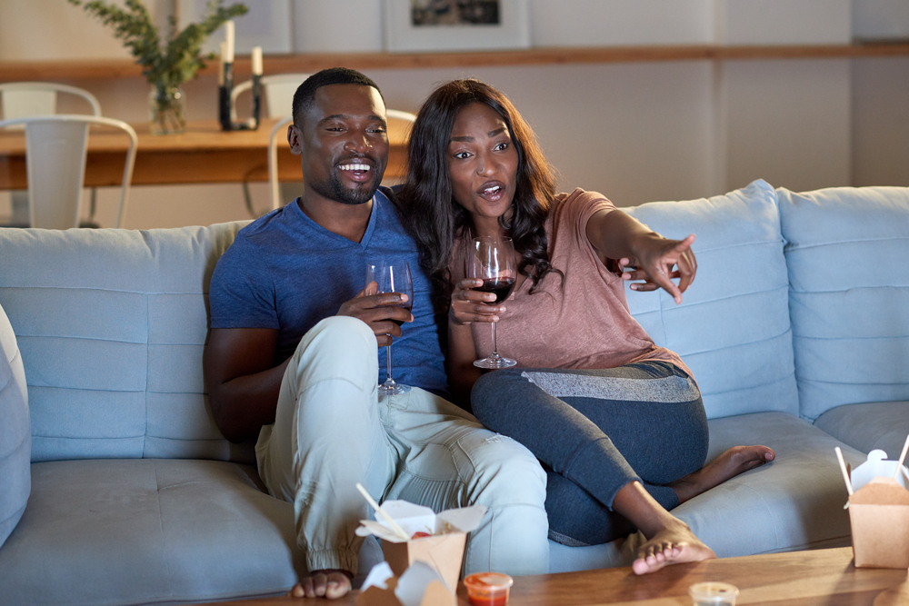 couple enjoying date night at home with wine and a movie