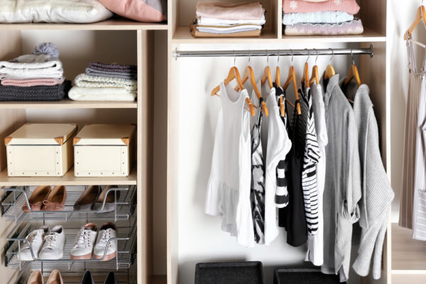 a beautifully organized closet with minimal clothing - how to declutter your life