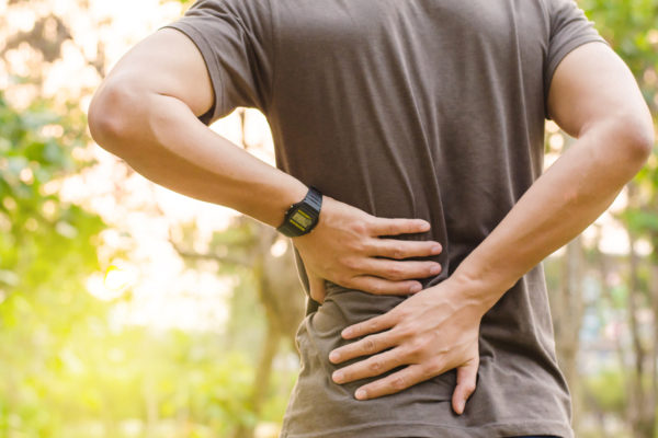 man on a run holding his lower back considering how to improve posture