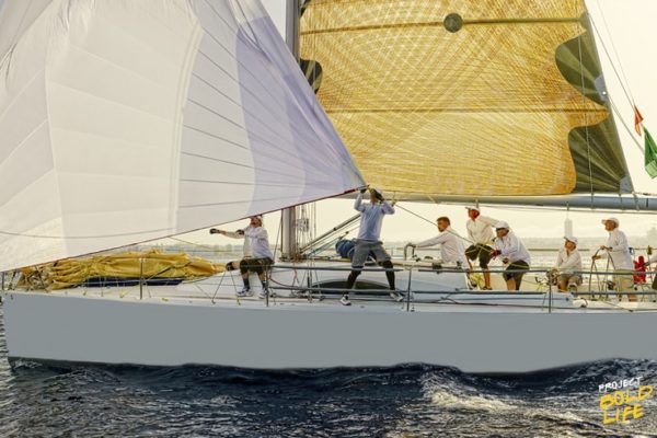 sailing team on the ocean racing a sailboat