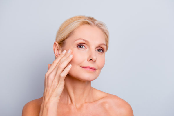 middle-aged woman with beautiful skin using anti-aging skin care