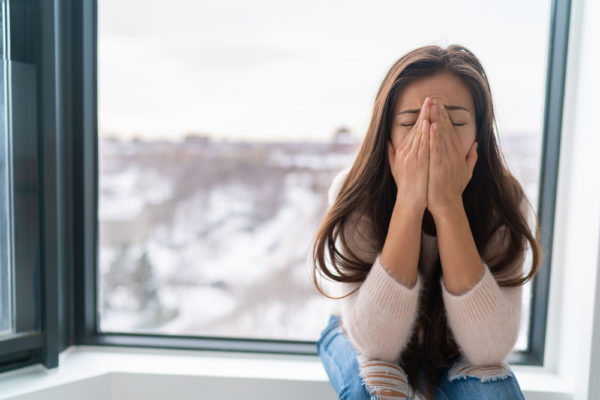 girl sitting at a window managing an anxiety attack or a panic attack