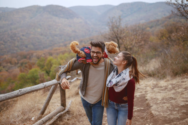 couple with dog enjoying the fall season