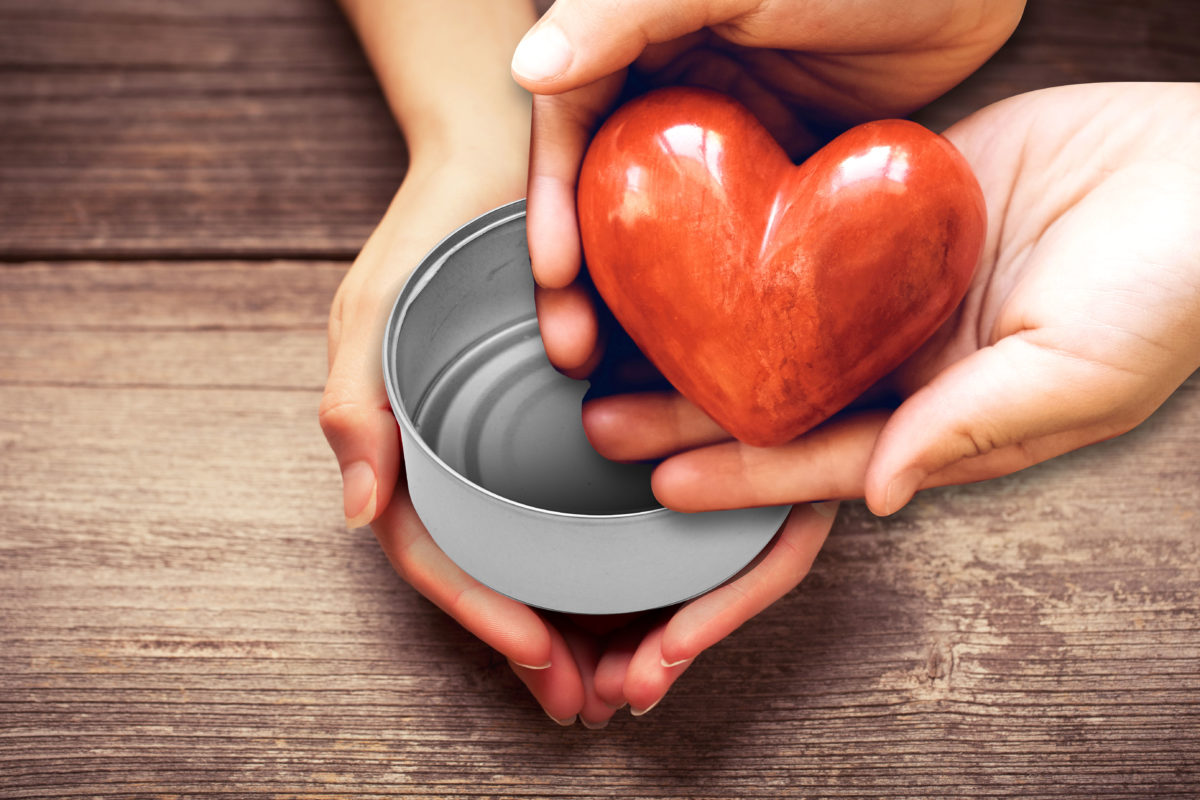 image of a pair of hands holding up an empty can while the hands of a giver place a heart-shaped offering inside it