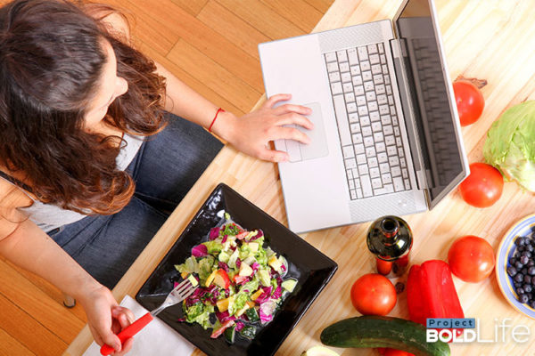 someone working and eating a salad