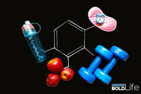 A water bottle, some apples, weights a watch and a face mask