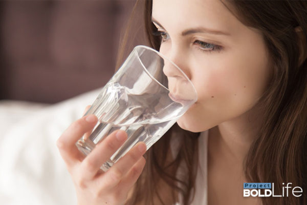 A woman recovering from coronavirus by drinking a glass of healing potion