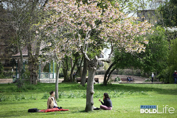 Some people chilling outside around a tree