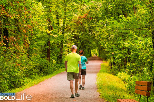 A couple power walking through the woods