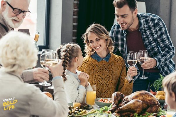 A family having a Thanksgiving dinner and drinking wine