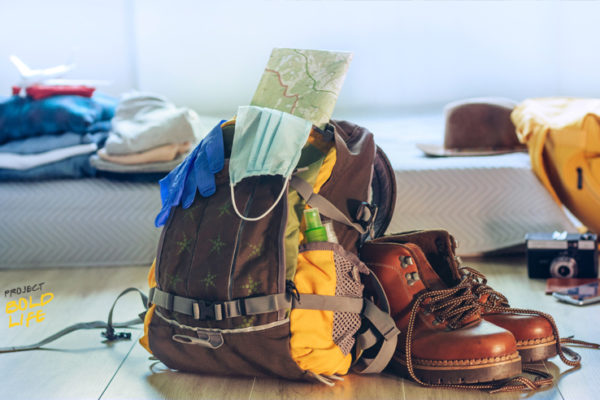 Some hiking books, a backpack, and a mask