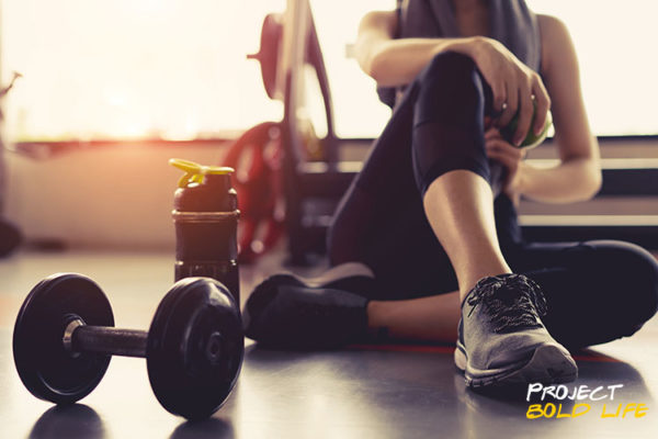 Some woman post-workout with a dumbbell and water bottle