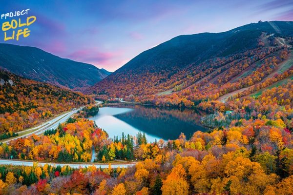 A road winding around a lake and going through a valley