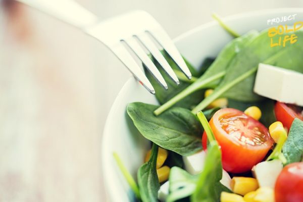 Someone eating a salad with everything in it